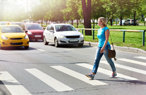 woman crossing the street. Avoiding pedestrian accidents by using a crosswalk.