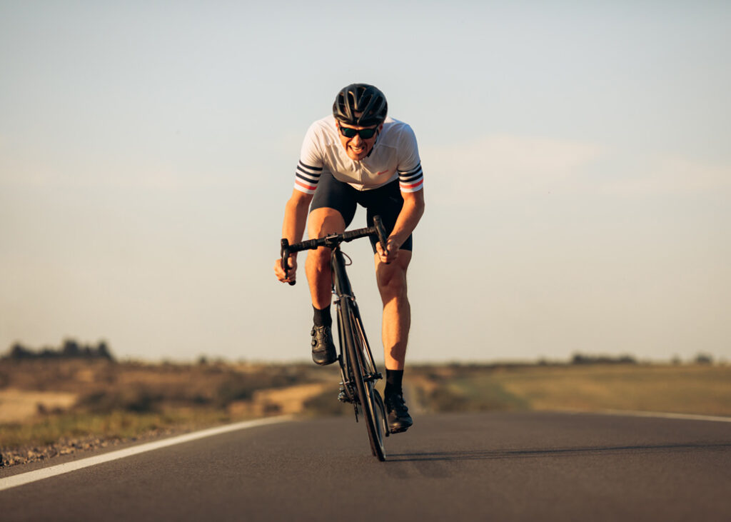 Happy road cyclist in protective helmet