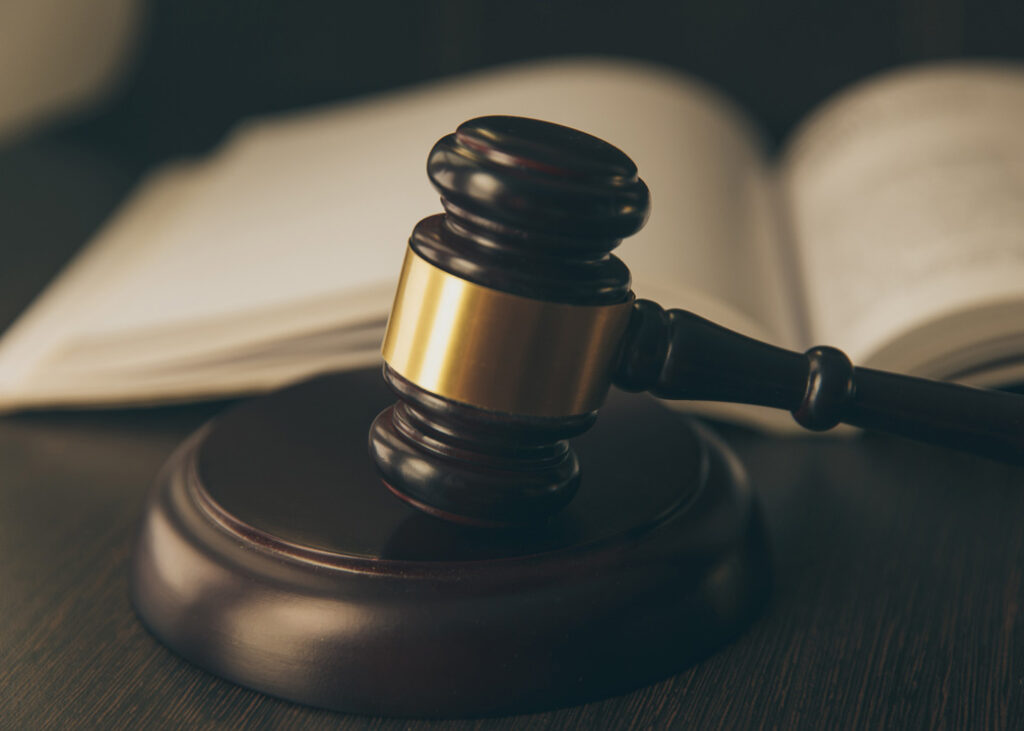 Open law book with a wooden judges gavel