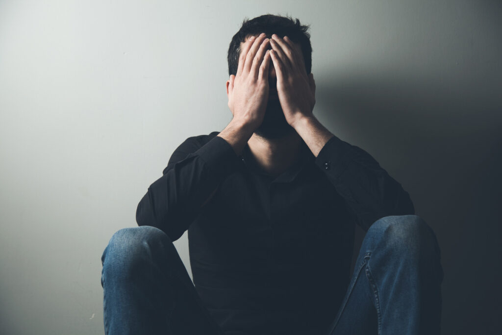 sad man sitting hand in face