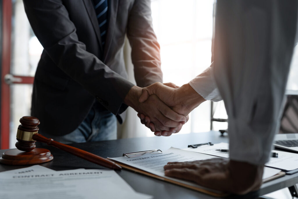 The handshake after a good cooperation, consulting between attorney and client, businessman, tax and real estate project company. Law and justice concept