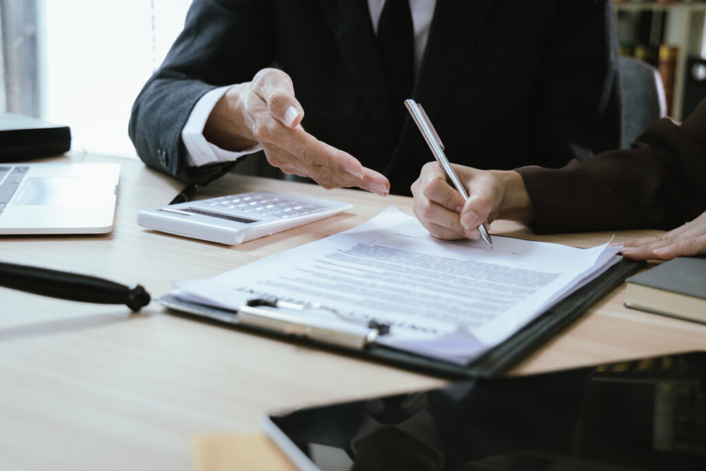 Close up of male lawyer working with contract documents and wooden hammer on table in courtroom. Justice and law. Judge in suit or lawyer working with documents. Law. Close up.