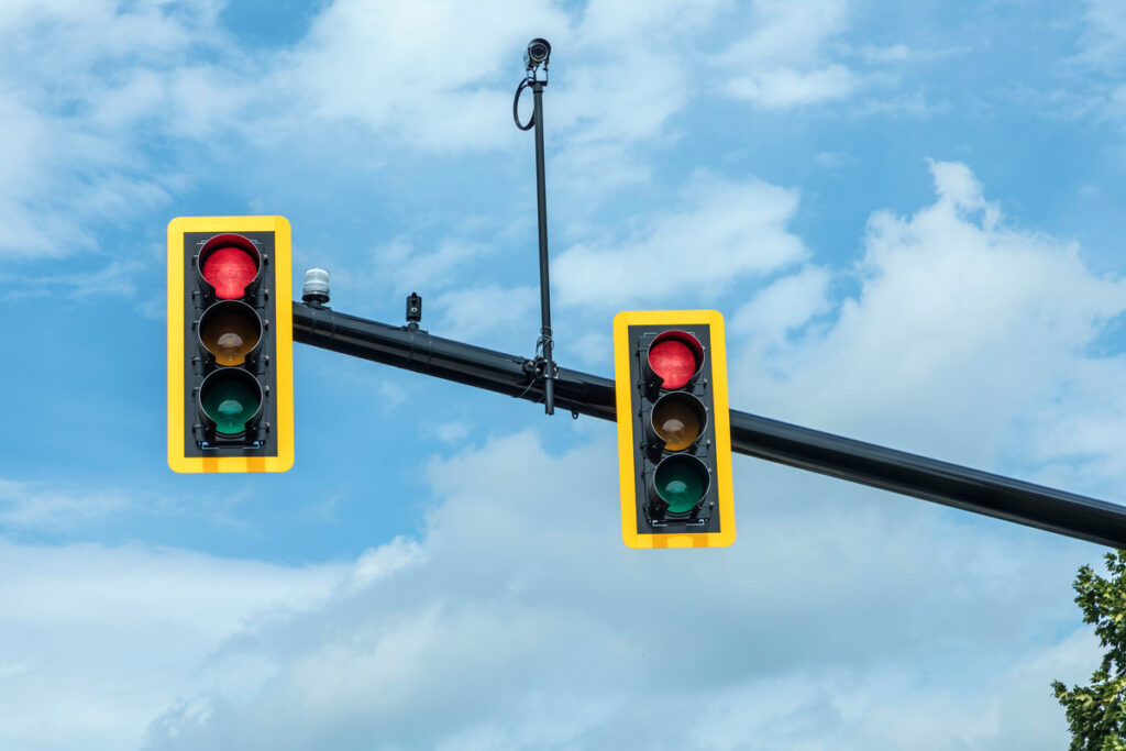 red traffic light at hanging lamp under blue sky