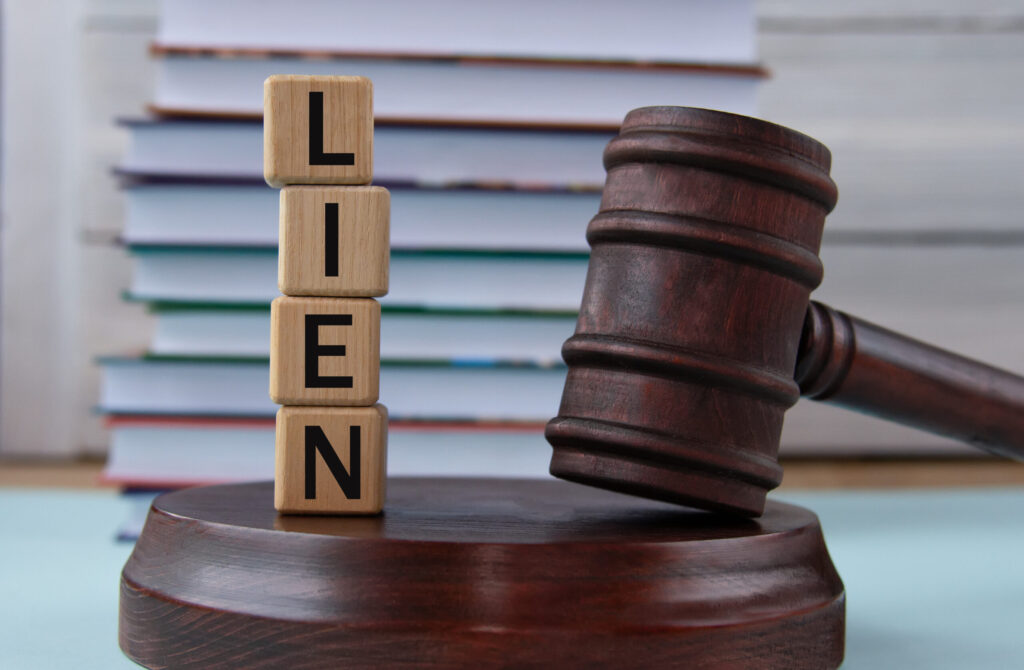 The word LIEN on wooden cubes against the background of the judge's gavel and stand. Business concept