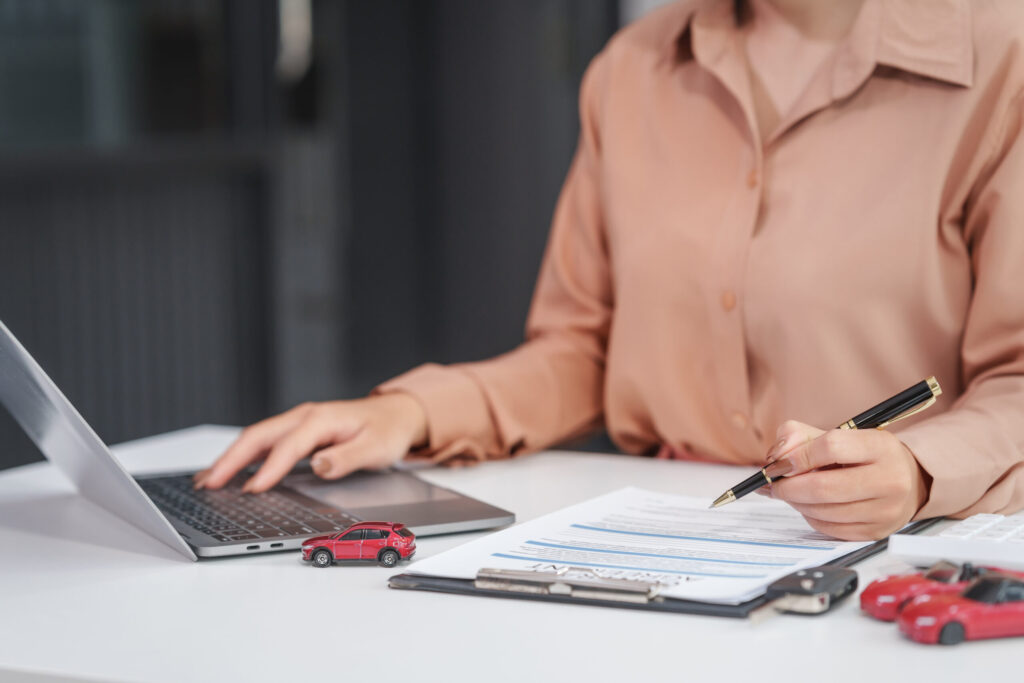 Asian businesswoman negotiates the sale of a car, discussing insurance and financing options, used car loans, premiums, deductibles, and various coverage types to ensure comprehensive protection.