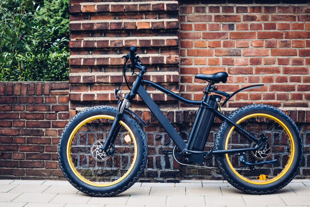 City electric bicycle near a brick wall. Ecological urban transport.