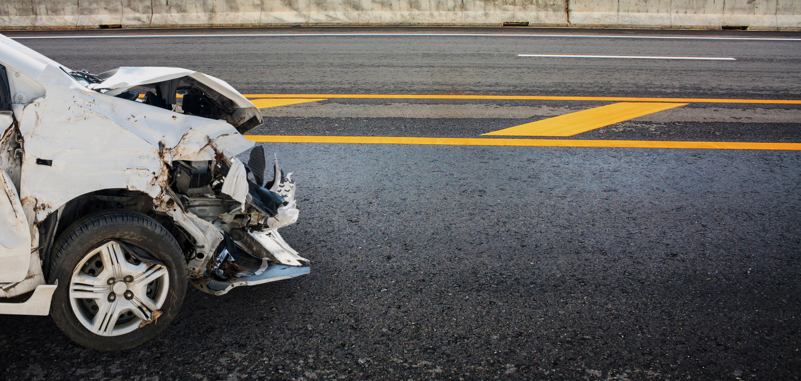 Damaged car after a crash on a California highway, illustrating a fault-based accident claim
