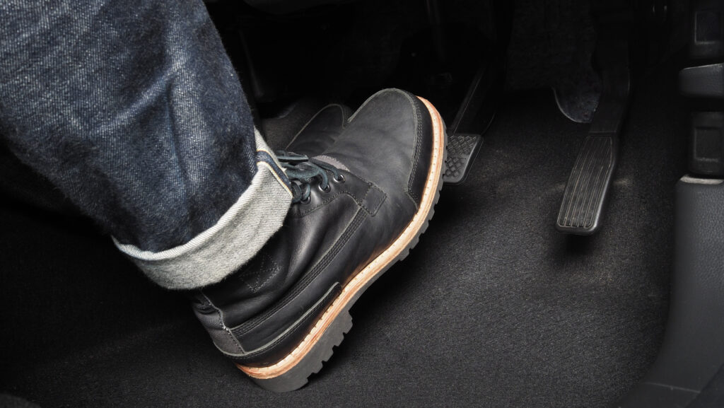 Accelerator and breaking pedal in a car. Close up the foot pressing foot pedal of a car to drive ahead. Driver driving the car by pushing accelerator pedals of the car. inside vehicle.
