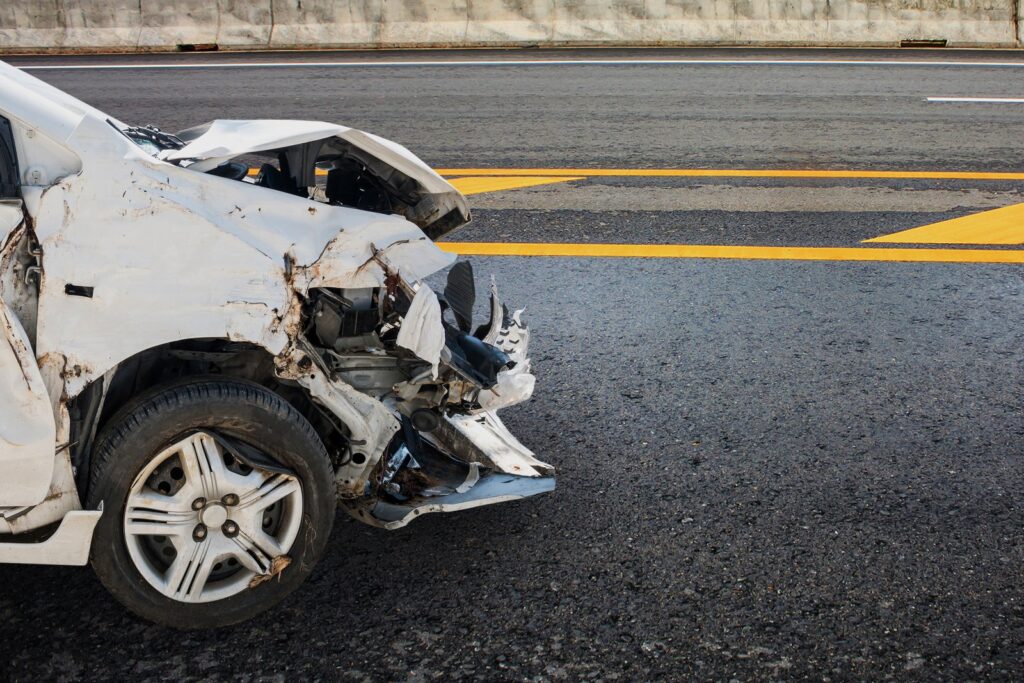 Damaged car after a crash on a California highway, illustrating a fault-based accident claim