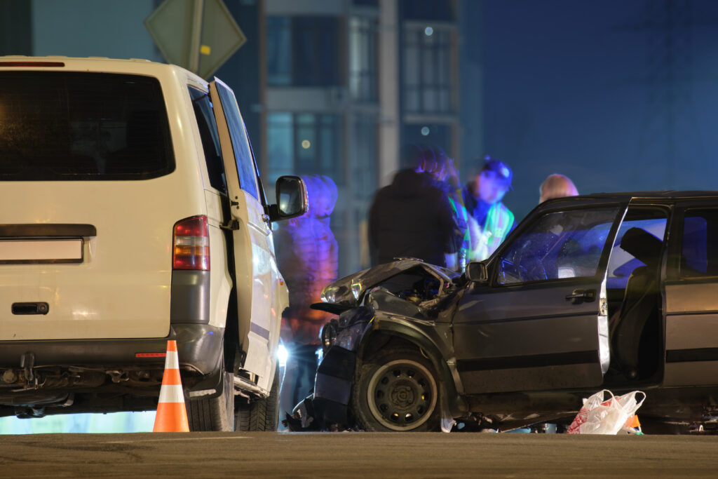 Cars involved in a nighttime road accident with a police report being documented
