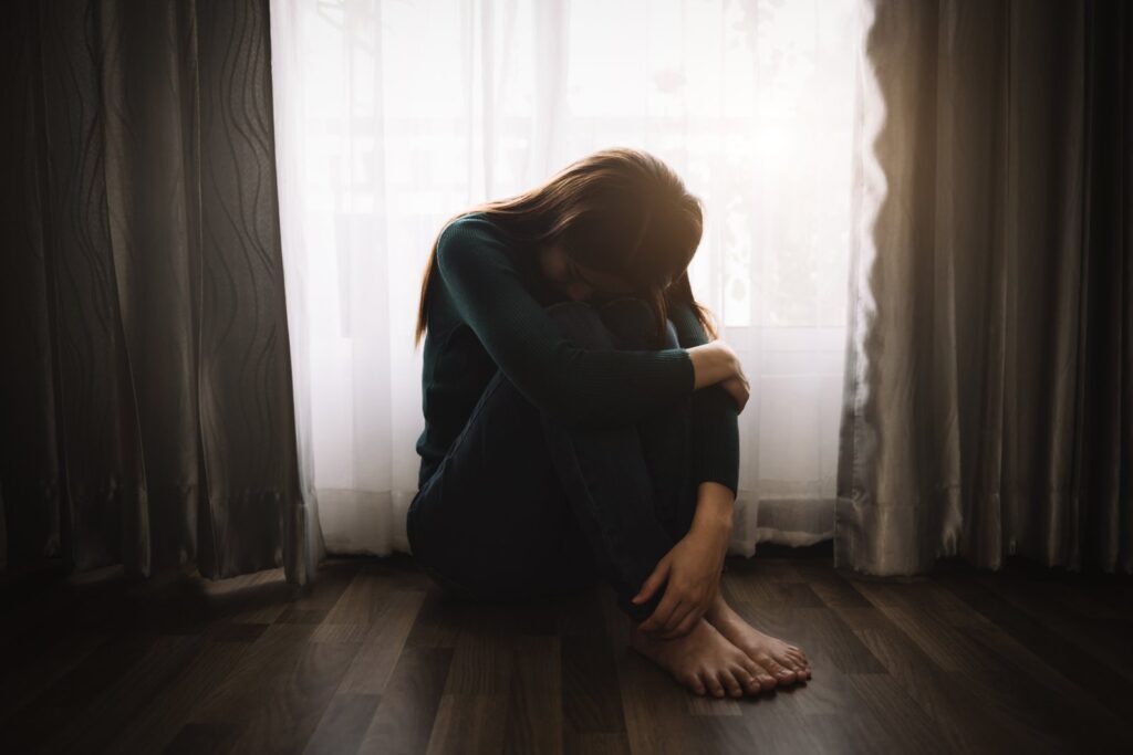 Woman sitting alone experiencing anxiety and emotional distress after a California accident