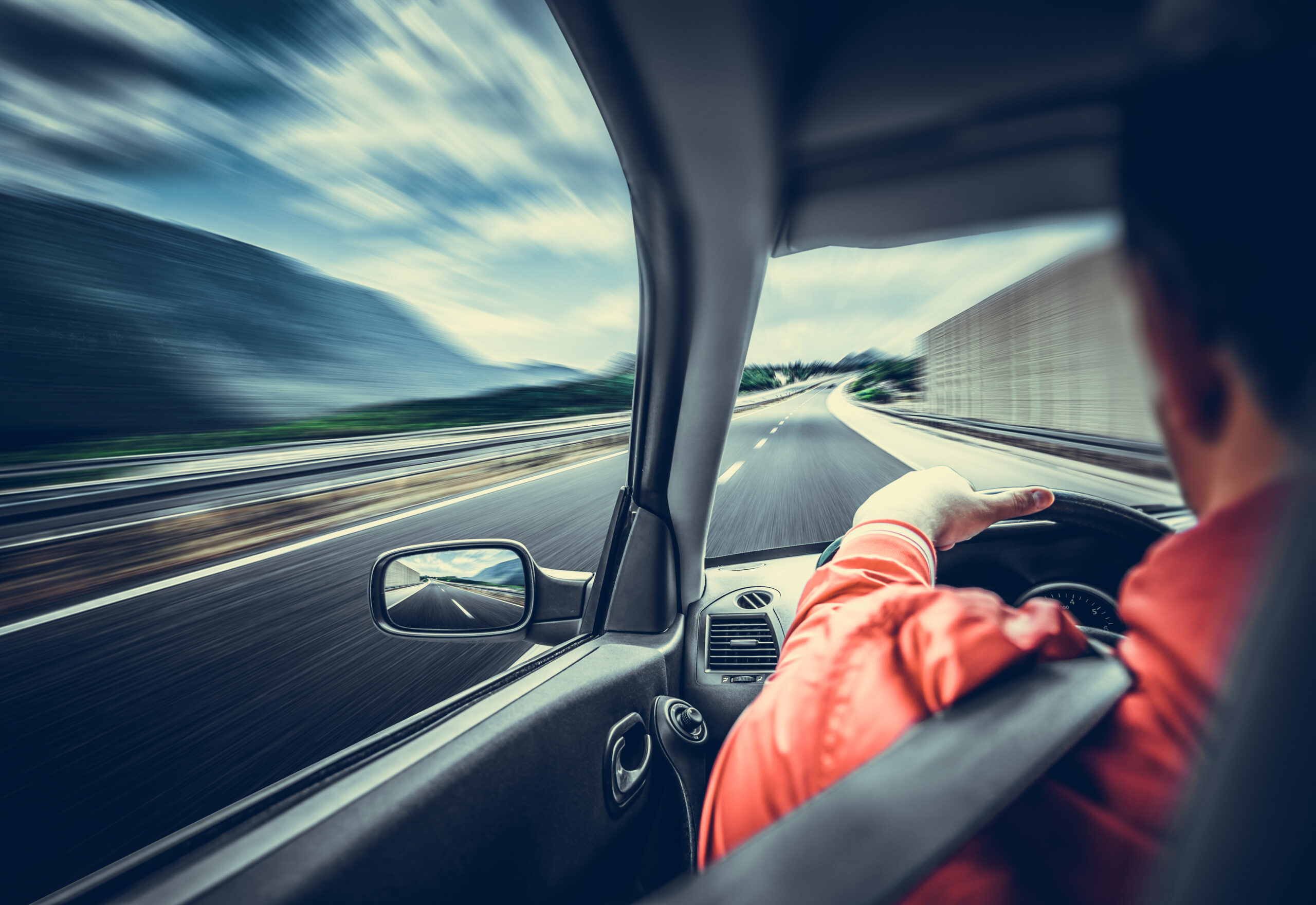 Driver rushing along the highway, illustrating a car accident claim involving a passenger who grabbed the steering wheel