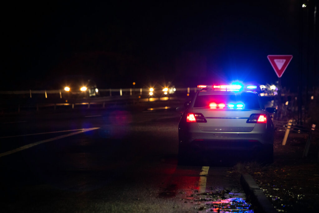 Police emergency flash lights at night from the back on highway road